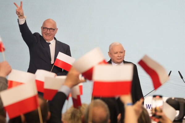Conservative Law and Justice party leader Jaroslaw Kaczynski, right, joins supporters during Poland's local and regional elections in Warsaw, Poland, Sunday April 7, 2024. The vote is the first test at the ballot box for Prime Minister Donald Tusk four months after he took office. (AP Photo/Czarek Sokolowski)