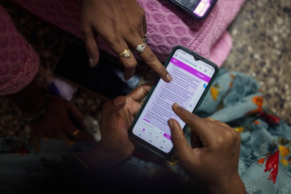 Women learn to use a chatbot powered by artificial intelligence developed by Myna Mahila Foundation at the local women's organization’s office in Mumbai, India, Feb. 1, 2024. The chatbot, currently a pilot project, represents what many hope will be part of the impact of AI on health care around the globe: to deliver accurate medical information in personalized responses that can reach many more people than in-person clinics or trained medical workers. (AP Photo/Rafiq Maqbool)