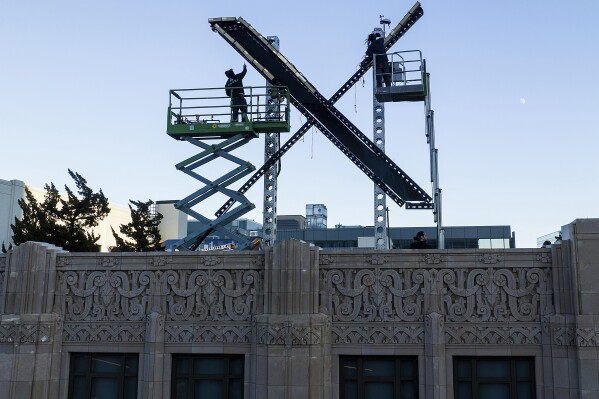 Workers install lighting on an "X" sign atop the downtown San Francisco building that housed what was formally known as Twitter, now rebranded X by owner Elon Musk, Friday, July 28, 2023. (AP Photo/Noah Berger)
