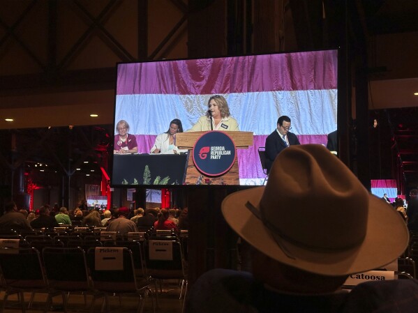 An attendee watches as Amy Kremer asks delegates to elect her to the Republican National Committee, Saturday, May 18, 2024, at the Georgia Republican Party State Convention in Columbus, Ga. Delegates voted for Kremer, who helped organize the pro-Donald Trump rally, Jan. 6, 2021, that led to a mob storming the U.S. Capitol. (AP Photo/Jeff Amy)