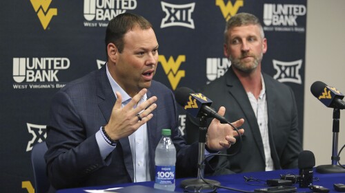 West Virginia athletic director Wren Baker, left, and interim NCAA college basketball coach Josh Eilert, right, answer questions during a news conference, Monday, June 26, 2023, in Morgantown, W.Va. (AP Photo/Kathleen Batten)