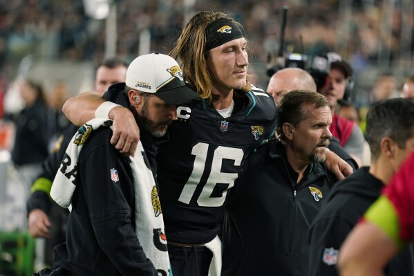 Jacksonville Jaguars quarterback Trevor Lawrence (16) is assisted off the field after he was injured during the second half of an NFL football game against the Cincinnati Bengals, Monday, Dec. 4, 2023, in Jacksonville, Fla. (APPhoto/John Raoux)