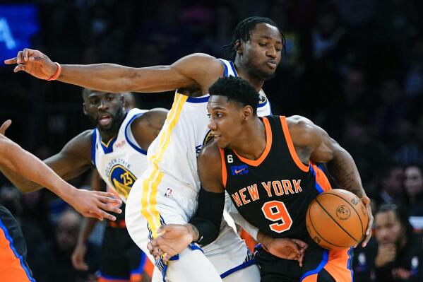 New York Knicks' RJ Barrett (9) drives past Golden State Warriors' Jonathan Kuminga (00) during the first half of an NBA basketball game Tuesday, Dec. 20, 2022, in New York. (AP Photo/Frank Franklin II)