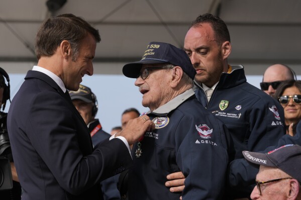 French President awards American WW II veteran Dick Rung with the Legion of Honor during an international ceremony at Omaha Beach, Thursday, June 6, 2024 in Normandy near Saint-Laurent-sur-Mer. Normandy is hosting various events to officially commemorate the 80th anniversary of the D-Day landings that took place on June 6, 1944. (AP Photo/Viginia Mayo, Pool)