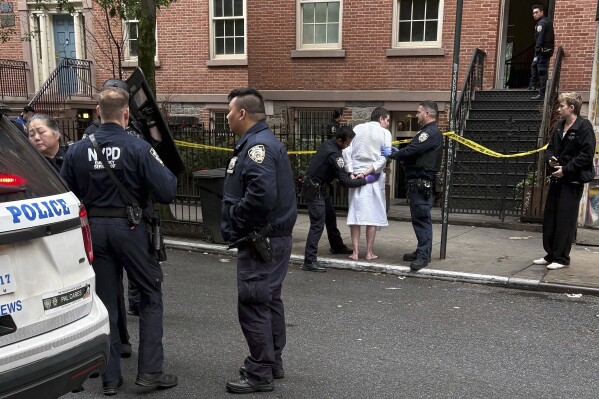 New York police officers arrest John Woeltz, Friday, May 23, 2025, in New York, who was charged with kidnapping, assaulting and holding a man against his will for several weeks in an upscale Manhattan town house.(AP Photo/Kava Gorna via AP)