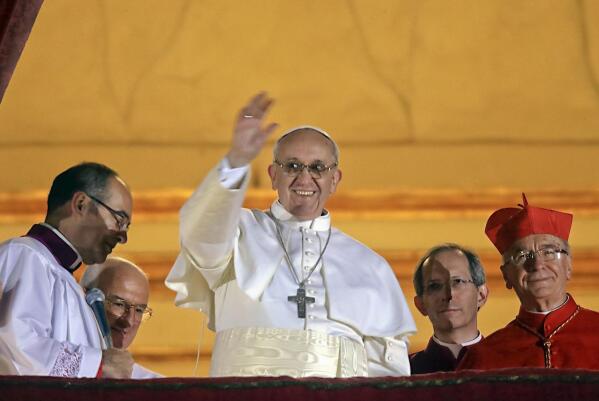 FILE - Pope Francis waves to the crowd from the central balcony of St. Peter's Basilica at the Vatican, March 13, 2013. When Jorge Bergoglio of Argentina became Pope Francis, much of his home country celebrated as if it had just won a soccer World Cup championship. A decade later, the first Latin American leader of the Catholic Church generates divided opinions. (AP Photo/Gregorio Borgia, File)