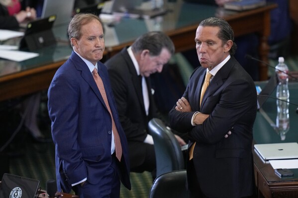 Texas state Attorney General Ken Paxton, left, stands with his attorney Tony Buzbee, right, before his impeachment trial in the Senate Chamber at the Texas Capitol, Tuesday, Sept. 5, 2023, in Austin, Texas. (AP Photo/Eric Gay)