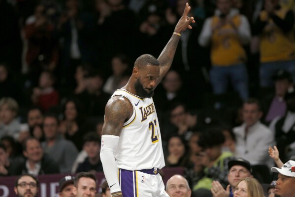 Los Angeles Lakers forward LeBron James acknowledges cheers from the crowd as he heads to the bench late in the fourth quarter of the team's NBA basketball game against the Brooklyn Nets on Sunday, March 31, 2024, in New York. (AP Photo/John Munson)