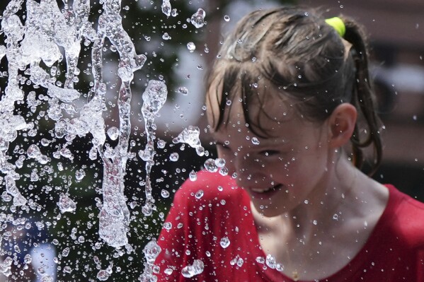 Bay Puro cools off at a fountain during hot weather in Chicago, Sunday, June 22, 2025. (AP Photo/Nam Y. Huh)