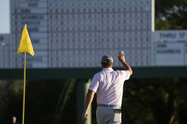 Bryson DeChambeau celebrates after chipping in for a birdie on the 18th hole during third round at the Masters golf tournament at Augusta National Golf Club Saturday, April 13, 2024, in Augusta, Ga. (AP Photo/Charlie Riedel)