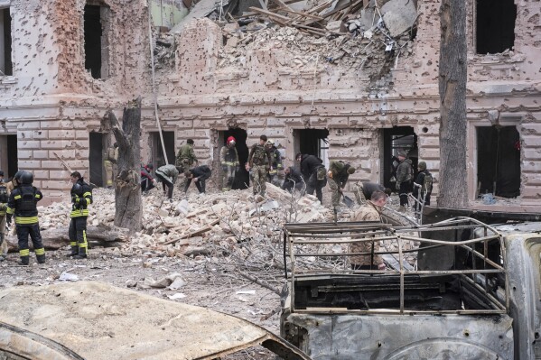 Rescue workers clear the rubble of a building hit by a Russian missile strike on Sumy, Ukraine, Sunday April 13, 2025. (AP Photo/Volodymyr Hordiienko)