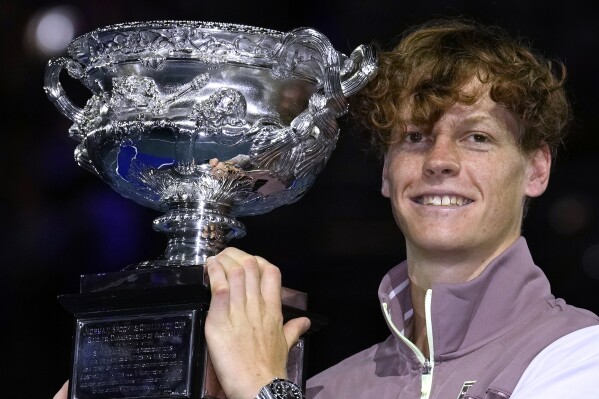 Jannik Sinner of Italy holds the Norman Brookes Challenge Cup aloft after defeating Daniil Medvedev of Russia in the men's singles final at the Australian Open tennis championships at Melbourne Park, in Melbourne, Australia, Sunday, Jan. 28, 2024. (AP Photo/Andy Wong)