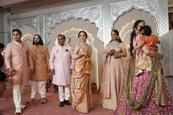 Billionaire Mukesh Ambani, third left, stands with his family members from L to R, son Akash, son Anant, wife Nita, daughter Isha and daughter-in-law Shloka at the wedding of his son Anant Ambani and Radhika Merchant at Jio World Convention Centre in Mumbai, India, Friday, July 12, 2024. (AP Photo /Rajanish Kakade)