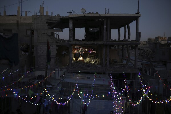 Palestinians hang decorations next to their destroyed homes in preparation for the holy month of Ramadan in Khan Younis, southern Gaza Strip, Friday, Feb. 28, 2025. (AP Photo/Jehad Alshrafi)
