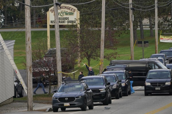 FILE - A body is wheeled out on a stretcher at Schemengees Bar and Grille, Oct. 26, 2023, in Lewiston, Maine. A Maine law that can be used to restrict access to guns during a mental health crisis has been invoked more than a dozen times since the Oct. 25 mass shooting in Lewiston — the deadliest in state history — with several people invoking the name of the gunman who killed 18 people. (AP Photo/Robert F. Bukaty, File)