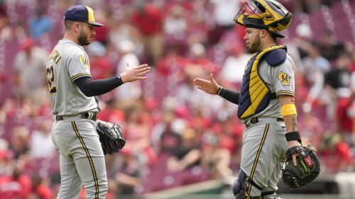 Nadhazovač Milwaukee Brewers Peter Strzelecki, vlevo, slaví s chytačem Victorem Karatinim po baseballovém zápase proti Cincinnati Reds v Cincinnati, neděle 4. června 2023. (AP Photo/Jeff Dean)