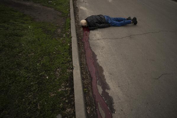 The body of a man killed during a Russian bombardment lies on a street in a residential neighborhood in Kharkiv, Ukraine, Tuesday, April 19, 2022. (AP Photo/Felipe Dana)