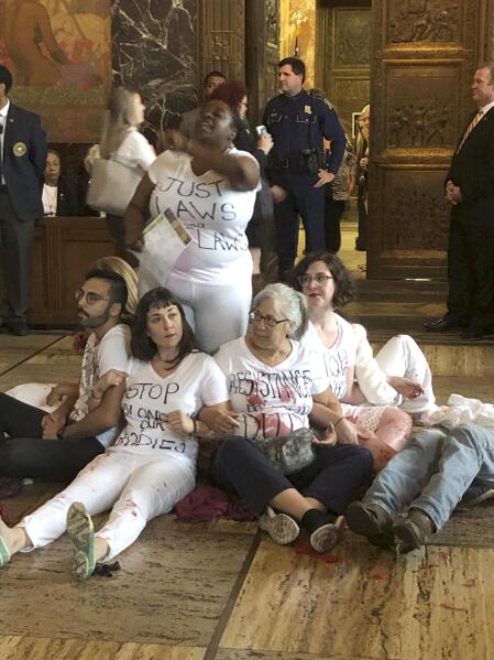 Abortion rights supporters protest outside the Louisiana House chamber, objecting to the advancement of a bill that would ban abortion when a fetal heartbeat is detected, on Wednesday, May 15, 2019, in Baton Rouge, La. (AP Photo/Melinda Deslatte)