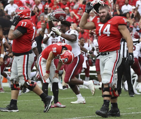 Georgia kicker Rodrigo Blankenship (98) bends over dejected reacting to missing a field goal attempt in double over time as South Carolina celebrates a 20-17 upset victory  in an NCAA college football game, Saturday, Oct., 12, 2019, in Athens, Ga. (Curtis Compton/Atlanta Journal-Constitution via AP)