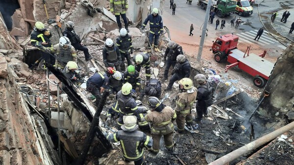 In this photo provided by the Ukrainian Police Press Office, emergency workers search for victims of the Russian rocket attack that damaged a multi-storey building in central Kharkiv, Friday, Oct. 6, 2023. (Ukrainian Police Press Office via AP)
