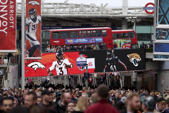 Football supporters arrive before the NFL football game between Denver Broncos and Jacksonville Jaguars at Wembley Stadium in London, Sunday, Oct. 30, 2022. (AP Photo/Ian Walton)