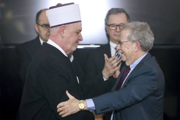 CAPTION CORRECTS ROLE OF ROSENSAFT General Counsel Emeritus of the World Jewish Congress Menachem Rosensaft, right, gestures with Bosnian Grand Mufti Husein Kavazovic, at the Srebrenica Memorial Center, on International Holocaust Remembrance Day, in Potocari, Bosnia, Saturday, Jan. 27, 2024. Jews and Muslims from Bosnia and abroad gathered in Srebrenica Saturday to jointly observe International Holocaust Remembrance Day and promote compassion and dialogue amid rising global sectarian hatred fueled by Israel’s war in Gaza. (AP Photo/Armin Durgut)