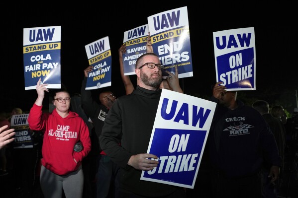 Striking United Auto Workers picket at Ford's Michigan Assembly Plant in Wayne, Mich., shortly after midnight Friday, Sept. 15, 2023. (AP Photo/Paul Sancya)