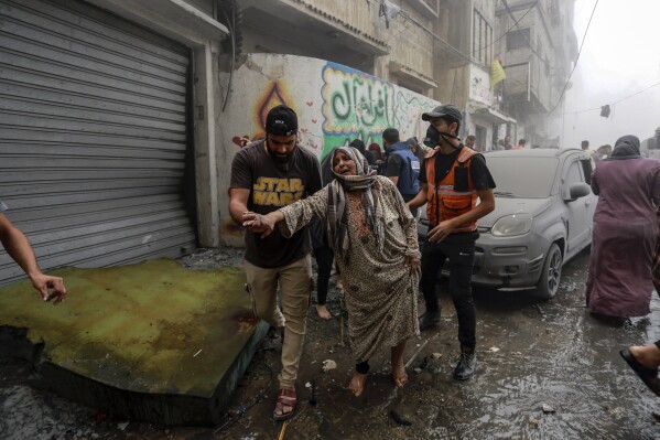 People help evacuate a Palestinian woman following Israeli airstrikes that targeted her neighbourhood in Gaza City, Monday, Oct. 23, 2023. (AP Photo/Abed Khaled)
