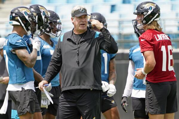 FILE - Jacksonville Jaguars head coach Doug Pederson, center, directs an NFL football practice, Monday, May 23, 2022, in Jacksonville, Fla. At right is quarterback Trevor Lawrence. Pederson is trying to help his players “heal” after last year's tumultuous season and hoping to build a winning culture that could lead Jacksonville out of the AFC South cellar for the first time since 2017. (AP Photo/John Raoux, File)