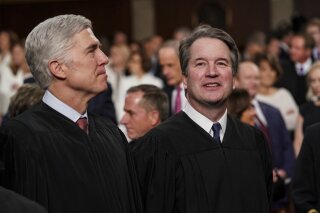 FILE - In this Feb. 5, 2019 file photo, Supreme Court Associate Justices Neil Gorsuch, left, and Brett Kavanaugh watch as President Donald Trump arrives to give his State of the Union address to a joint session on Congress at the Capitol in Washington. President Donald Trump’s deep imprint on the federal courts is a rare point of agreement about the president across the political spectrum. With a major assist from Senate Majority Leader Mitch McConnell, Trump and his White House staff relentlessly, almost robotically, filled nearly every opening in the federal judiciary, undeterred by Democratic criticism. (Doug Mills/The New York Times via AP, Pool, File)