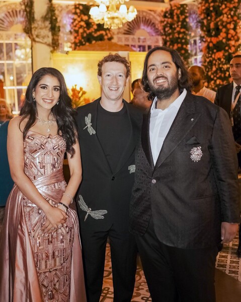 This photograph released by the Reliance group shows Mark Zuckerberg, center, posing for a photograph with billionaire industrialist Mukesh Ambani's son Anant Ambani, right, and Radhika Merchant at their pre-wedding bash in Jamnagar, India, Saturday, Mar. 02, 2024. (Reliance group via AP)