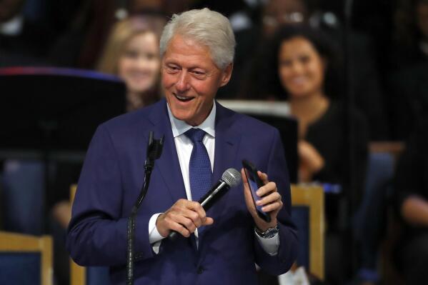 FILE - Former President Bill Clinton smiles as he plays a recording of Aretha Franklin on his phone during the funeral service for Franklin at Greater Grace Temple, Friday, Aug. 31, 2018, in Detroit. World Central Kitchen founder Jose Andres, Jordan’s Queen Rania, BlackRock CEO Larry Fink and “Hamilton” creator Lin-Manuel Miranda will help relaunch the Clinton Global Initiative in Sept. 2022, when the gathering of international dignitaries returns after six years. (AP Photo/Paul Sancya, File)