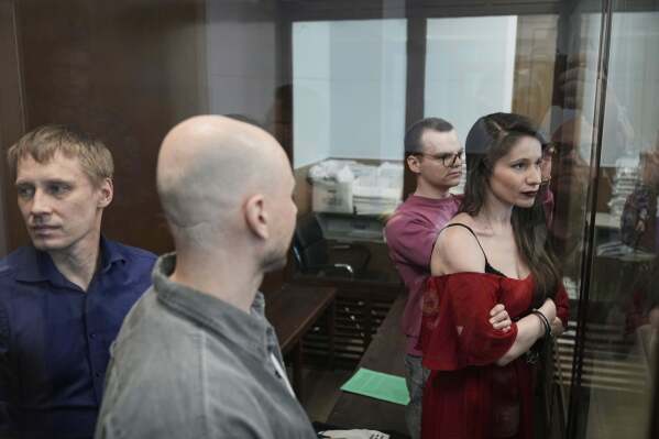 Russian journalists, from left, Konstantin Gabov, Sergey Karelin, Artyom Kriger and Antonina Favorskaya, accused of working for a group founded by the late Russian opposition politician Alexei Navalny, stand in a defendant's cage of the Nagatinsky District Court in Moscow, Russia, Tuesday, April 15, 2025. (AP Photo)