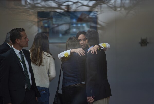 María Claudia Tarazona, al centro, esposa del senador colombiano Miguel Uribe Turbay, abraza a unas personas en el hospital en que él está siendo atendido tras ser baleado en un mitin, el 11 de junio de 2025, en Bogotá, Colombia. (AP Foto/Ramón Espinosa)