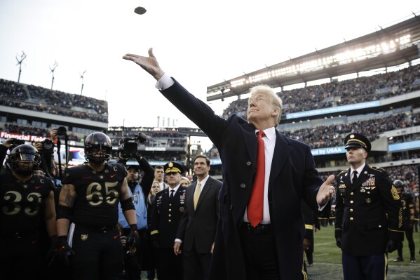 ARCHIVO - En esta foto de archivo del 8 de diciembre de 2018, el presidente Donald Trump lanza la moneda antes del partido de fútbol americano universitario de la NCAA entre el Ejército y la Marina en Filadelfia. El partido número 120 entre el Ejército y la Marina está programado para el sábado en Filadelfia. El presidente Donald Trump asistirá a su segundo partido consecutivo entre el Ejército y la Marina. Los presidentes, por costumbre, se sientan en el lado del Ejército del estadio durante una mitad y en el lado de la Marina durante la otra. (Foto AP/Matt Rourke, Archivo)