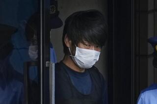 FILE - Tetsuya Yamagami, the alleged assassin of Japan’s former Prime Minister Shinzo Abe, gets out of a police station in Nara, western Japan, on July 10, 2022, on his way to local prosecutors' office. The suspect will be detained until late November for mental evaluation so prosecutors can determine whether to formally press charges and sent him to trial for murder, officials said Monday.(Nobuki Ito/Kyodo News via AP, File)
