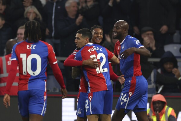 Crystal Palace's Michael Olise, centre, celebrates with teammates after scoring his side's opening goal during the English Premier League soccer match between Crystal Palace and Manchester United at Selhurst Park stadium in London, England, Monday, May 6, 2024. (AP Photo/Ian Walton)