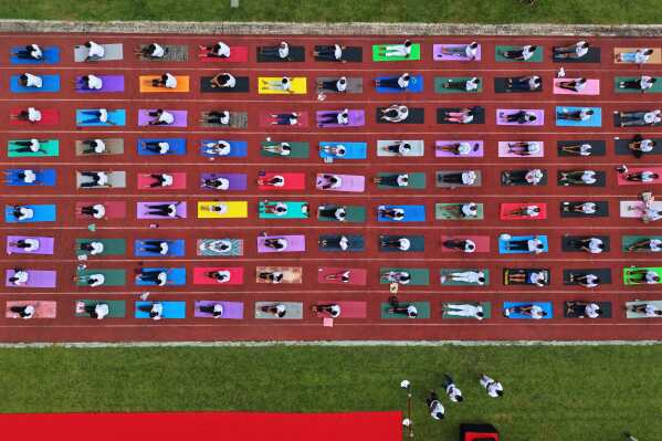 Indians perform yoga during an event to mark International Day of Yoga at a playground in Guwahati, India, Saturday, June 21, 2025. (AP Photo/Anupam Nath)