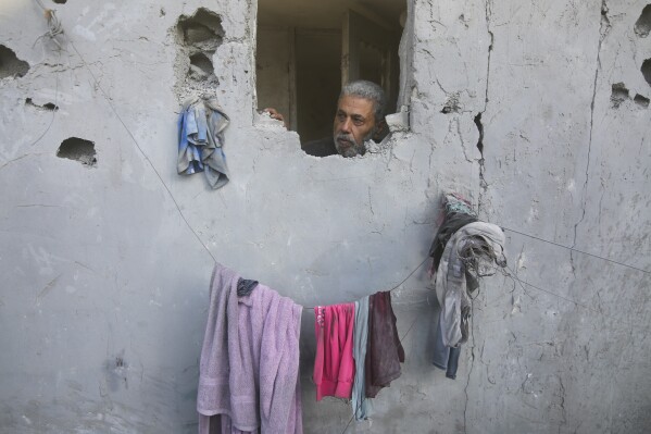 A Palestinian looks on from his house damaged by Israeli airstrikes in Rafah, southern Gaza Strip, Wednesday, Oct. 18, 2023. (AP Photo/Hatem Ali)