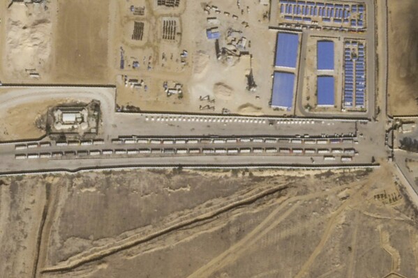This Thursday, Oct. 19, 2023 satellite photos analyzed on Friday by The Associated Press show a convoy of semitruck trailers lined up at the Rafah border crossing on the Egyptian side, likely waiting for approval to cross into the besieged Gaza Strip as the Israel-Hamas war rages. (Planet Labs PBC via AP)