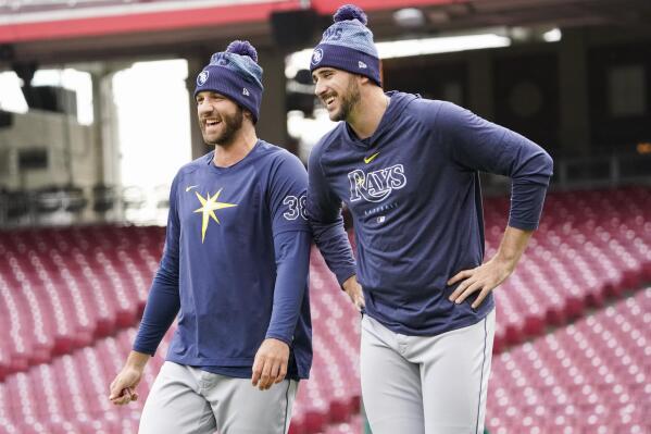 Tampa Bay Rays pitchers Colin Poche, left, and Jeffrey Springs, right, laugh during batting practice before a baseball game against the Cincinnati Reds, Monday, April 17, 2023, in Cincinnati. (AP Photo/Joshua A. Bickel)