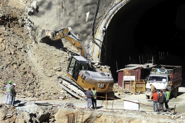 A heavy machinery works at the the entrance to the site of an under-construction road tunnel that collapsed in mountainous Uttarakhand state, India, Saturday, Nov. 18, 2023. Forty workers were trapped in the collapsed road tunnel in northern India for a seventh day Saturday as rescuers waited for a new machine to drill through the rubble so they could crawl to their freedom. (AP Photo)