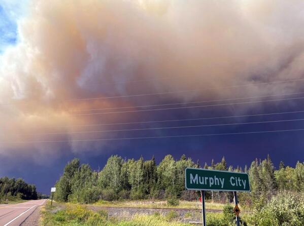 In this image provided by the U.S. Forest Service, smoke and a pyrocumulus cloud rise above Highway 1 near Murphy City, Minn, on Monday, Aug. 23, 2021, above the Greenwood Lake wildfire in northeastern Minnesota. U.S. Forest Service officials say the fire made a run Monday afternoon and developed a pyrocumulus cloud resulting in extreme fire behavior and fire-created lightning. The cloud was visible for miles in all directions and smoke and ash from the fire were reported as far away as Lutsen, a resort town on Lake Superior.(U.S. Forest Service via AP)