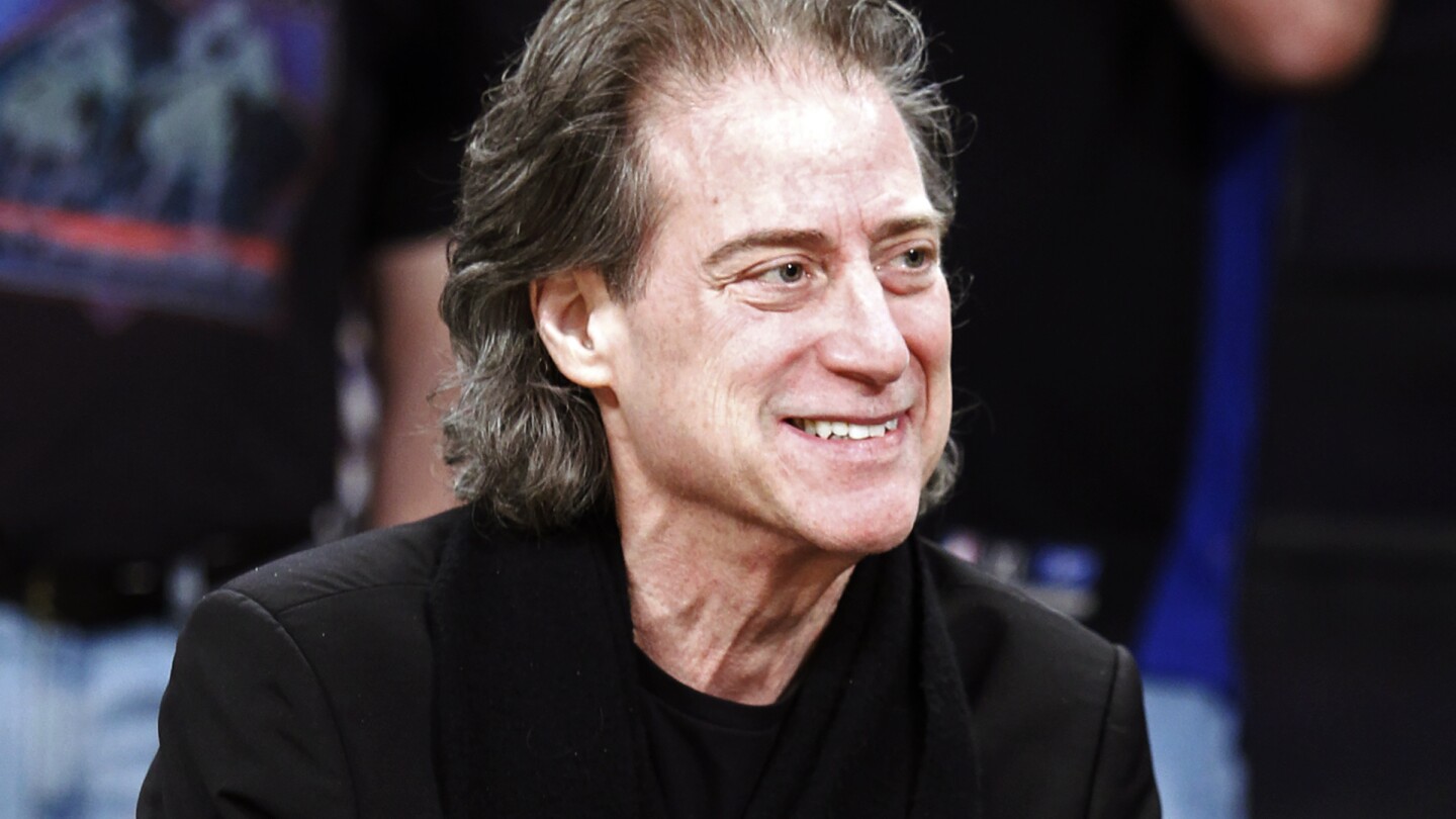 FILE - Comedian Richard Lewis attends an NBA basketball game in Los Angeles on Dec. 25, 2012. Lewis, an acclaimed comedian known for exploring his neuroses in frantic, stream-of-consciousness diatribes while dressed in all-black, leading to his nickname “The Prince of Pain,” has died. He was 76. He died at his home in Los Angeles on Tuesday night after suffering a heart attack, according to his publicist Jeff Abraham. (AP Photo/Alex Gallardo, File)