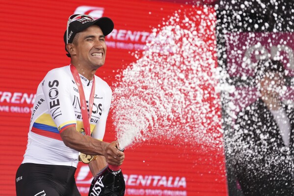 Jhonatan Narváez celebrates with sparkling wine on podium after winning the stage 1 of the Giro d'Italia from Venaria Reale to Turin, Italy, Saturday May 4, 2024. (Massimo Paolone/LaPresse via AP)