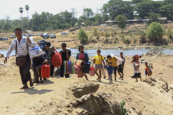 People cross the Moei river as they flee Myawaddy township in Myanmar to Thailand's Mae Sot town in Thailand's Tak province, Saturday, April 20, 2024. More than a thousand people have fled from eastern Myanmar into Thailand on Saturday as fresh fighting erupted near the border of the town that has recently been captured by guerillas from the Karen ethnic minority, officials said.(AP Photo/Warangkana Wanichachewa)