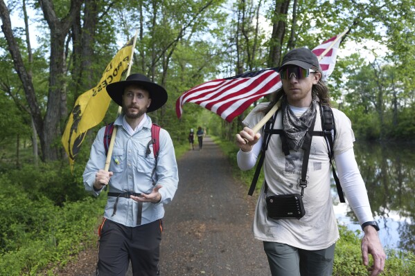 Max Goodman, left, and Ross Brubeck walk on a trail near Princeton, N.J., as part of a Quaker march from New York City to Washington D.C. to protest President Donald Trump's crackdown on immigrants on Wednesday May 7, 2025. (AP Photo/Luis Andres Henao)