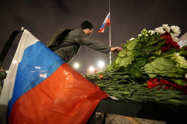 A man places flowers at a spontaneous memorial in memory of the victims of Moscow attack in St. Petersburg, Russia, Saturday, March 23, 2024. Russia's top state investigative agency says the death toll in the Moscow concert hall attack has risen to over 133. The attack Friday on Crocus City Hall, a sprawling mall and concert venue on Moscow's western edge, also left many wounded and left the building a smoldering ruin. (AP Photo/Dmitri Lovetsky)