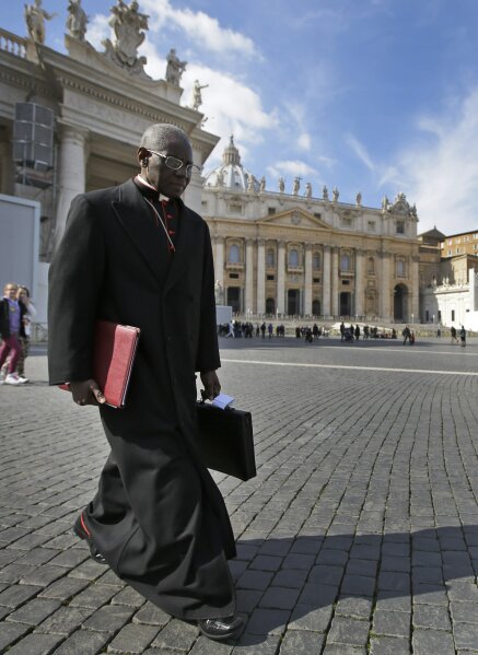 FILE - In this March 4, 2013 file photo, Cardinal Robert Sarah, of Guinea, walks in St. Peter's Square after attending a cardinals' meeting, at the Vatican. The Vatican said Saturday it was “necessary and urgent” to return to in-person Masses as soon as coronavirus lockdowns permit. (AP Photo/Andrew Medichini, File)