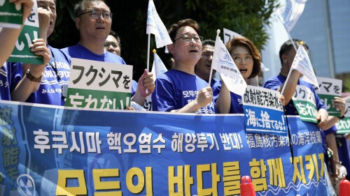 South Korean lawmakers hold placards and a banner against Japanese plans to release treated radioactive water from the damaged Fukushima nuclear power plant, during a rally in front of the Prime Minister's office Monday, July 10, 2023, in Tokyo. The small green placards in Japanese read, "(We) don't forget Fukushima!" The banner in Korean reads, "No dumping of Fukushima nuclear contaminated water at sea!," upper line, and "Let’s protect everyone’s sea together." (AP Photo/Eugene Hoshiko)